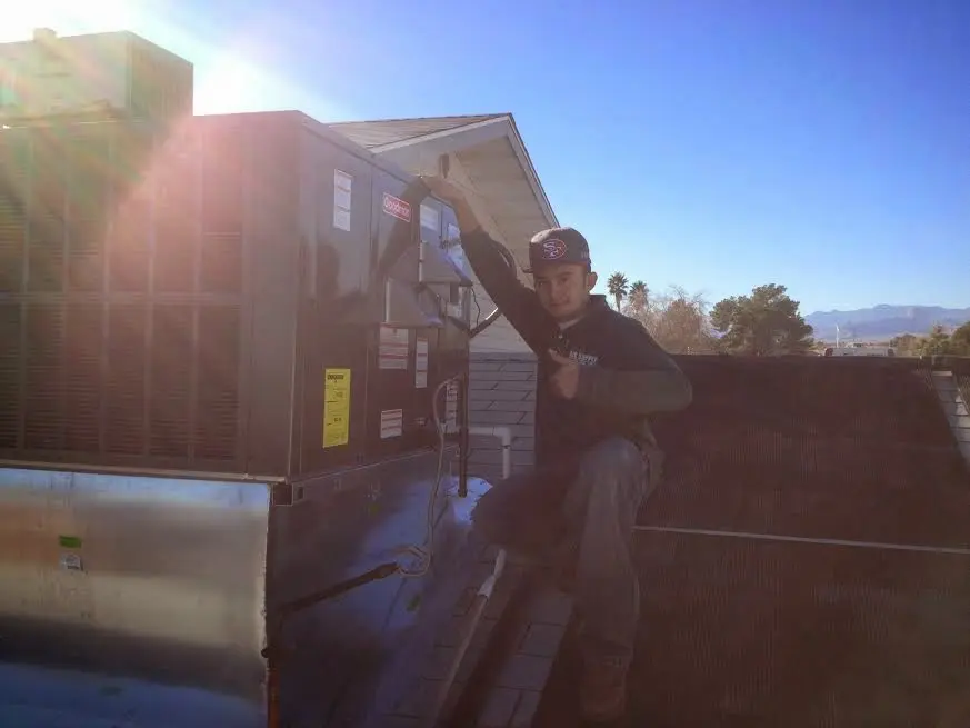HVAC technician performing HVAC Inspection on a rooftop unit in New Scotland